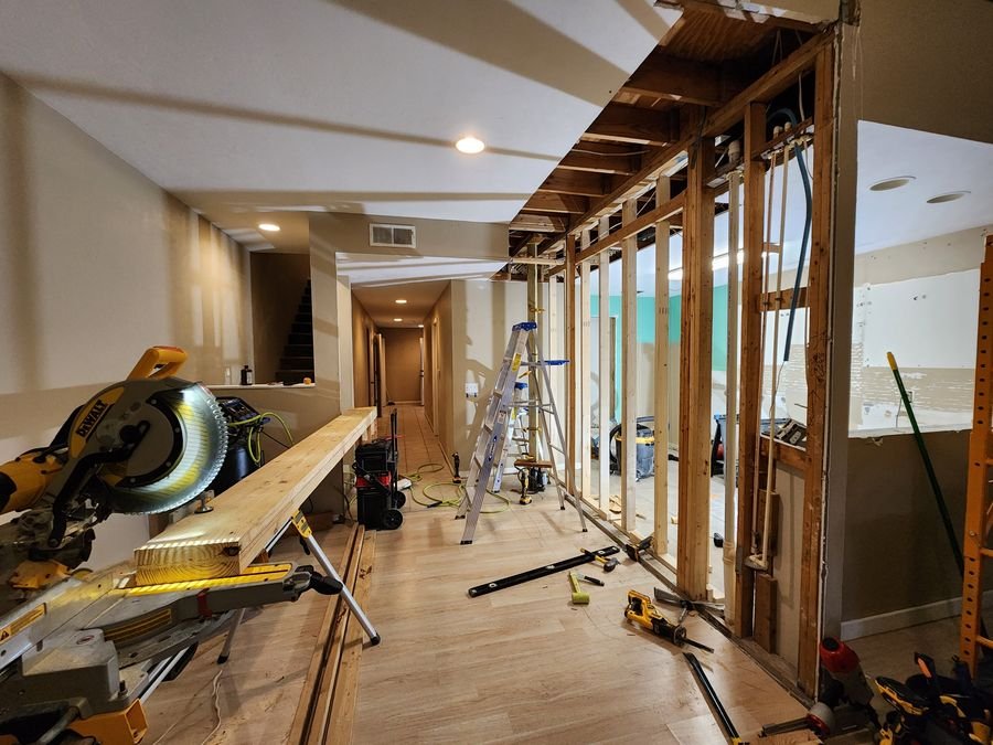 Miter saw cutting header lumber beside the framed opening