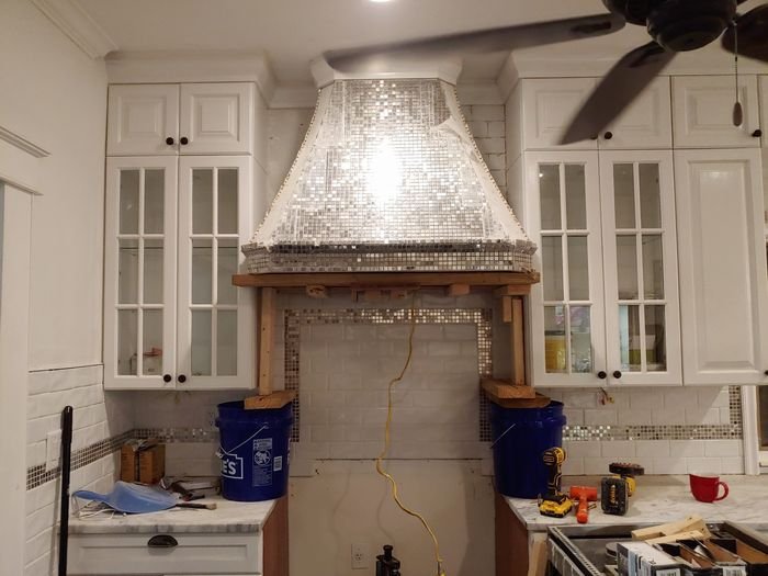 Mosaic range hood framed in wood