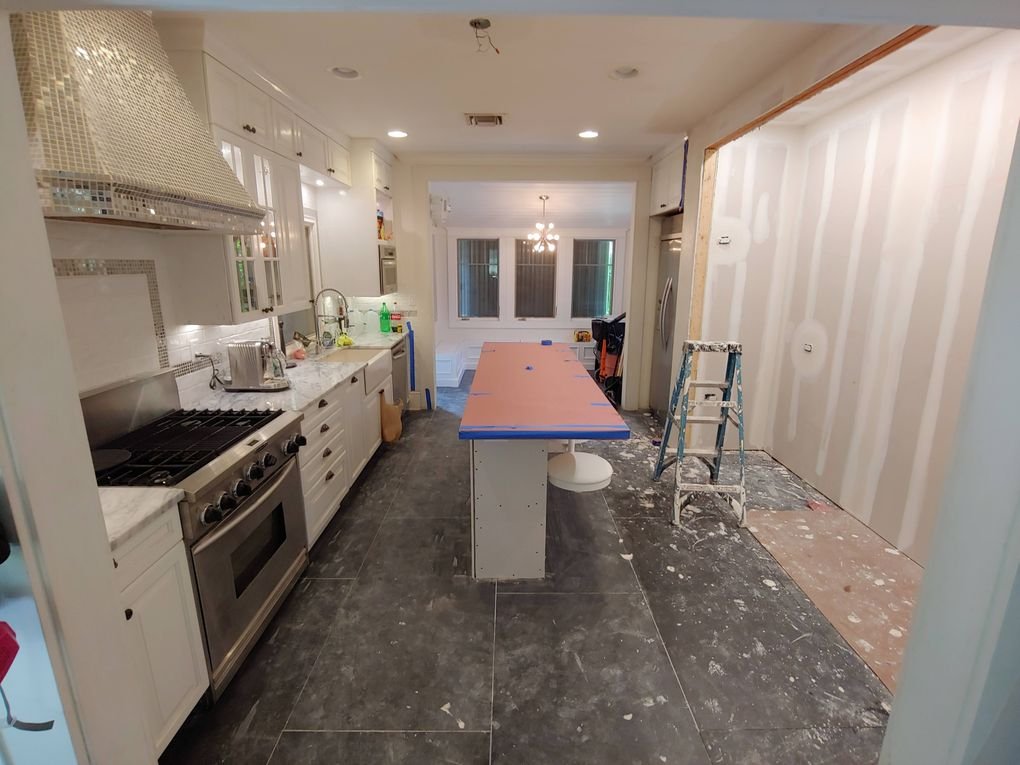 Kitchen during construction with drywall finishing and a taped island top